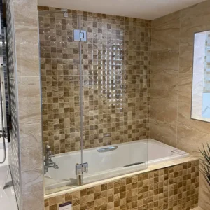 Leon Bath Screen fitted above a bath with clear glass and chrome fittings
