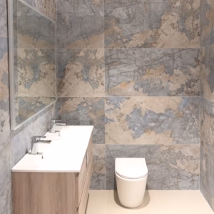 GemaStone Ocean 60x120 tiles installed in a bathroom showroom setting with blue-grey stone effect pattern.