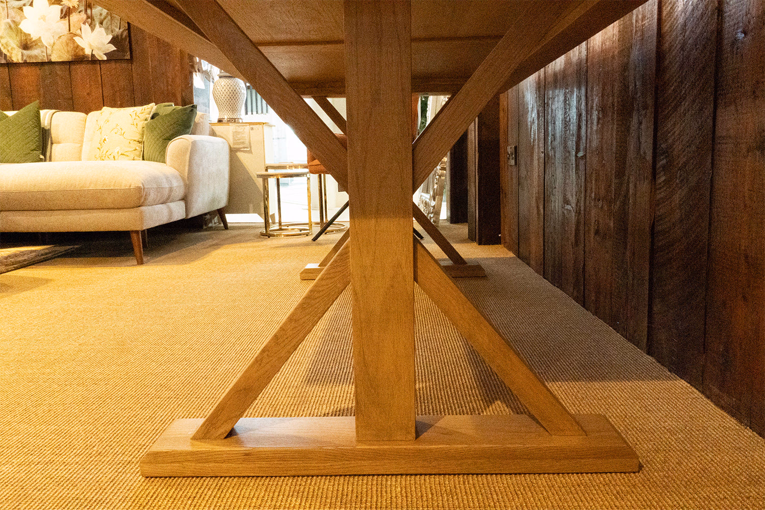 Close-up of the Harvard oak dining table x-frame leg detail.