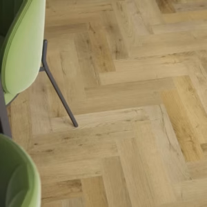 Privas Oak Herringbone laminate flooring shown in a room setting with warm oak herringbone detail.
